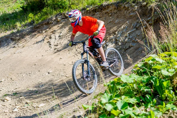 Hegyi kerékpáros kerékpározik a nyári hegyekben erdő táj. Ember kerékpározás Mtb áramlási pálya pálya. — Stock Fotó