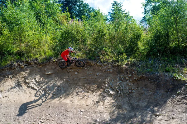 Hegyi kerékpáros kerékpározik a nyári hegyekben erdő táj. Ember kerékpározás Mtb áramlási pálya pálya. — Stock Fotó