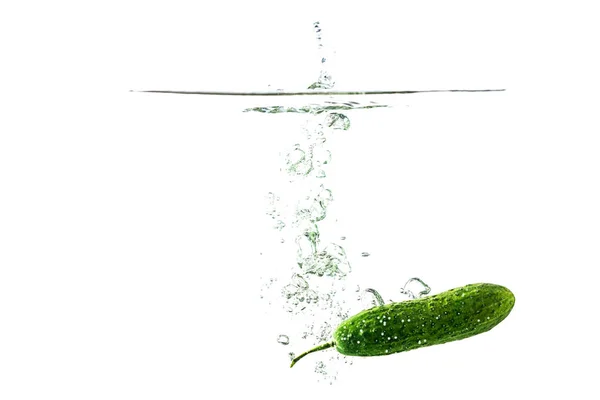 Green cucumber falls into the water scattering a lot of sprays and drops. — Stock Photo, Image
