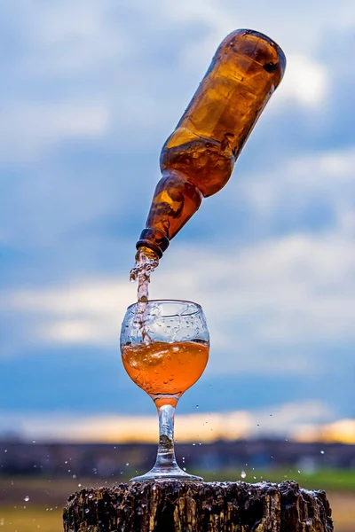 Flying bottle over a glass against the sky, magic.