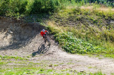 Dağ bisikleti süren ve taşların üzerinde kaskla gezen bir binici. Profesyonel bisikletçi, yokuş aşağı..