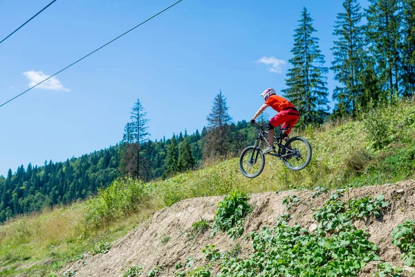 Professional cyclist on a mountain bike makes the jump, space. Active lifestyle, downhill.
