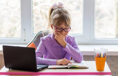 Küçük liseli kız ödev yapıyor. Mesafe öğrenme kavramı. Karantina sırasında evde eğitim.