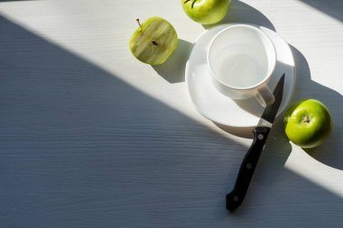 Çay fincanı ve yeşil elmalar ahşap bir masada, üst manzara, kopyalama alanı. Sağlıklı kahvaltı konsepti. Durgun hayat.