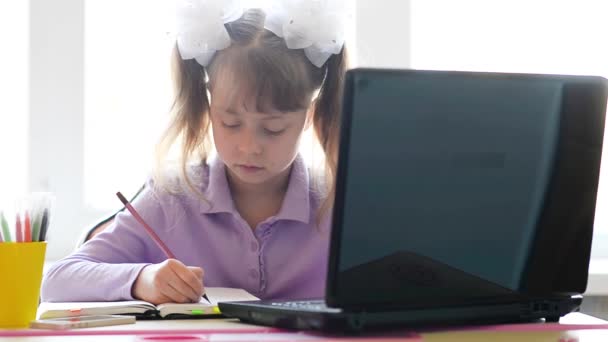 Een Schoolmeisje Werkt Een Laptop Herschrijft Tekst Een Notitieboekje Het — Stockvideo