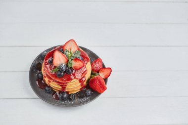  Krep, taze çilek, yaban mersini, nane ile kapatın ve beyaz bir arka plan üzerinde jam