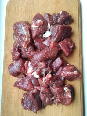 Beyaz bir zemin üzerinde dilimlenmiş et.