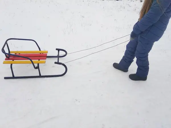 女の子は雪の中でそりを引く — ストック写真