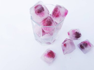 Beyaz arka planda kirazlı bir bardak.