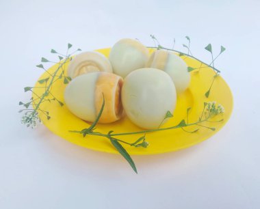 Beyaz arka planda bir tabakta haşlanmış yumurta.