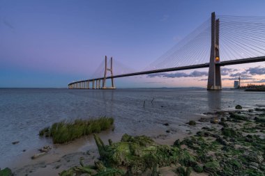 Ponte Vasco da Gama Köprüsü manzarası gün batımından sonra Rio Tejo nehrinin yanında.