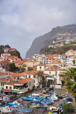 Camara de Lobos 'un Madeira' daki manzarası. Arka planda Cape Giro ve marinada tekneler.