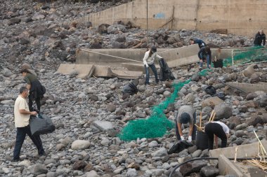 Ponta do Sol, Madeira 'daki fırtınadan sonra plajı temizleyen gönüllü insanlar.