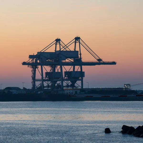 Portekiz 'de gün batımında vinçleri olan sinüs konteynır port terminali