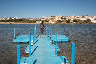 Woman at a beach pier in Vila Nova de Milfontes, in Portugal