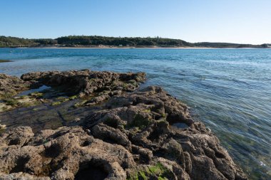 Vila Nova de Milfontes rocks beach with river Mira, in Portugal