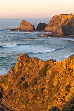 Woman on a cliff at Praia de Odeceixe in Costa Vicentina, Portugal