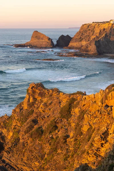 Woman on a cliff at Praia de Odeceixe in Costa Vicentina, Portugal