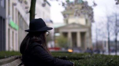 Girl/Woman filming/photographing Brandenburger Tor between flowers in Berlin