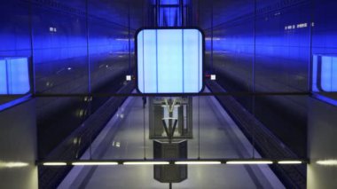 İnsanlar Hamburg 'daki Speicherstadt bölgesindeki Hafencity Üniversitesi metro istasyonunda yürüyor ve bekliyor.