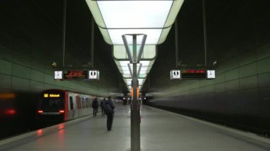 İnsanlar Hamburg 'daki Speicherstadt bölgesindeki Hafencity Üniversitesi metro istasyonunda yürüyor ve bekliyor.