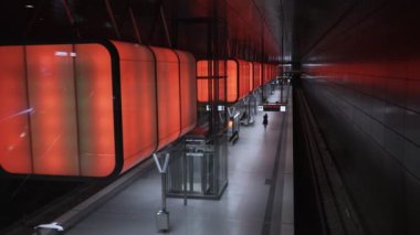İnsanlar Hamburg 'daki Speicherstadt bölgesindeki Hafencity Üniversitesi metro istasyonunda yürüyor ve bekliyor.