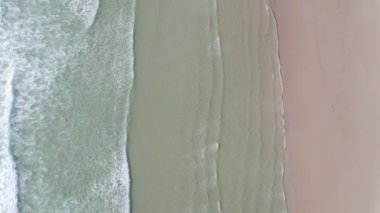 İnsansız hava aracı cennetin üzerinde turkuaz deniz suyu, İspanya 'daki kumsal manzarasına dalgalar çarpıyor.