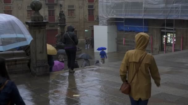 女性の女の子の旅行者は サンティアゴ コンポステーラ市で黄色のジャケットと雨の日に歩いて スペイン — ストック動画