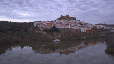 Mertola şehir manzarası gün batımında Alentejo, Portekiz 'de Guadiana nehri ile