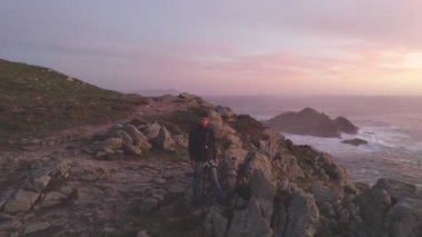 Fotoğrafçı İHA hava görüntüsü İspanya 'da, güneş batarken Cape Tourinan Deniz Feneri' nin deniz manzarası görüntüsünü çekiyor.