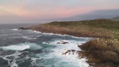 İspanya 'da, gün batımında Pembe bulutlu Cape Tourinan Deniz Feneri' nin inanılmaz hava aracı manzarası