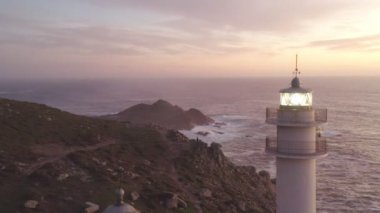 İspanya 'da, gün batımında Pembe bulutlu Cape Tourinan Deniz Feneri' nin inanılmaz hava aracı manzarası