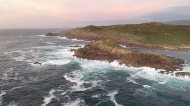 İspanya 'da, gün batımında Pembe bulutlu Cape Tourinan Deniz Feneri' nin inanılmaz hava aracı manzarası