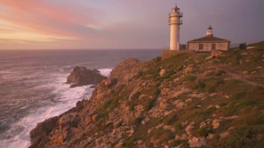 İspanya 'da gün batımında Pembe bulutlu Cape Tourinan Deniz Feneri manzarası