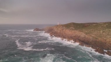 İspanya 'da, gün batımında Pembe bulutlu Cape Tourinan Deniz Feneri' nin inanılmaz hava aracı manzarası