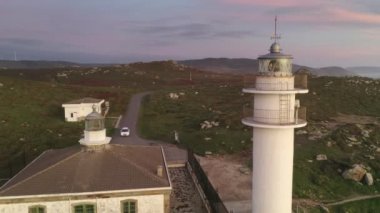 İspanya 'da, gün batımında Pembe bulutlu Cape Tourinan Deniz Feneri' nin inanılmaz hava aracı manzarası