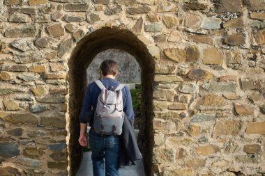 Portekiz, Mertola Alentejo 'da kale duvarında yürüyen bir turist.