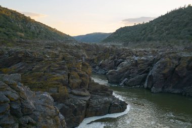 Portekiz, Mertola Alentejo 'da gün batımında nehir guadiana ve kaya detayları ile Pulo do Lobo şelalesi