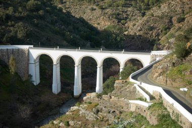 Mertola güzel beyaz ve taş köprü şehir girişinde Alentejo, Portekiz manzarasında badem ağaçları ile