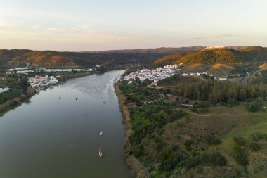 İspanya 'da Sanlucar de Guadiana' nın ve Portekiz 'de Alcoutim' in Guadiana Nehri 'nde yelkenli teknelerle hava aracı görüntüsü.