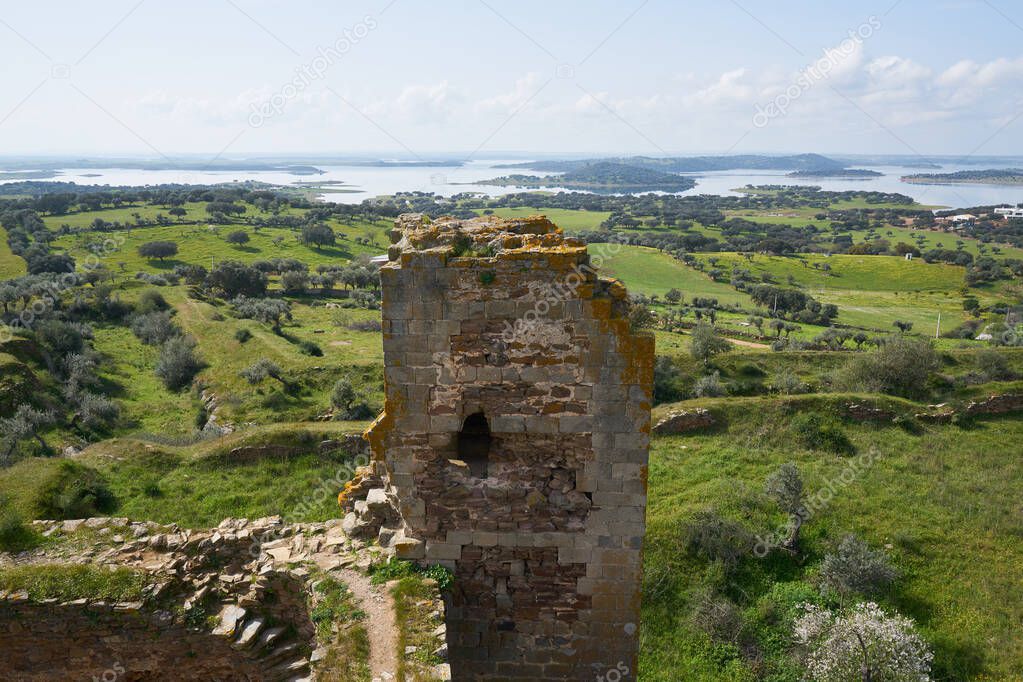 Mourao castle towers and wall historic building with alqueva dam reservoir in Alentejo, Portugal