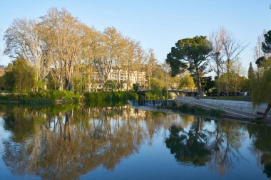 Tomar 'da güneş doğarken Portekiz' de su değirmeni olan bir bahçe parkı.