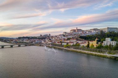 Mondego nehri ve Portekiz 'deki güzel tarihi binalarla gün batımında Coimbra insansız hava aracı şehir manzarası