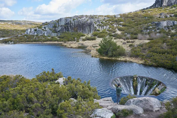 Portekiz, Serra da Estrela 'da Covao dos Conchos gölünün fotoğraflarını çeken bir kadın.