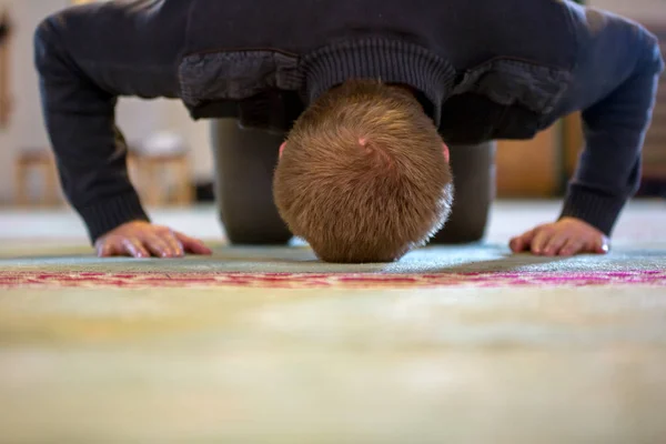 イスラム教徒の男性が祈り、彼の額や手を床に置く — ストック写真
