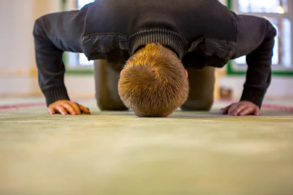Μουσουλμανική άνθρωπος προσεύχεται, βάζοντας το μέτωπο και τα χέρια στο πάτωμα — Φωτογραφία Αρχείου