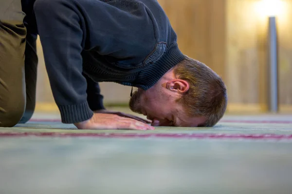 Muslimischer Mann betet, legt Stirn und Hände auf den Boden — Stockfoto