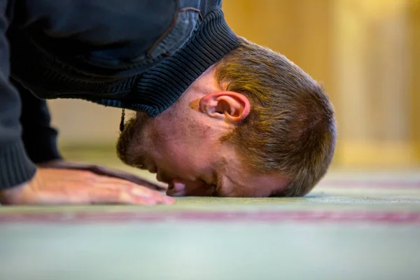 Muslimischer Mann betet, legt Stirn und Hände auf den Boden — Stockfoto