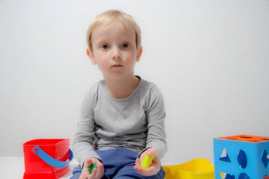 Küçük çocuk üç yaşında masada oturur ve plas ile çalış