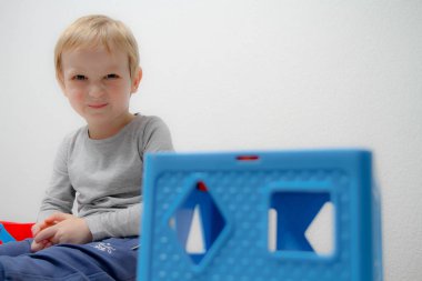 Küçük çocuk üç yaşında masada oturur ve plas ile çalış